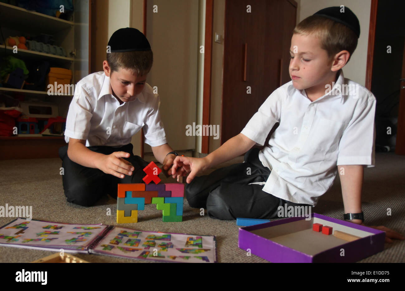 (140601) -- JERUSALEM, June 1, 2014 (Xinhua) -- Tzviel Noyman (L) and his brother Dudik Noyman assemble building blocks at their home in Beit Shemesh, about 20 km from Jerusalem, on May 30, 2014. Tzviel Noyman is an Israeli Ultra-Orthodox boy in a family with six children, three boys and three girls. He is ten years old this year and a grade three pupil of Torat Moshe elementary school, which is only opened to Jewish children. Tzviel has eight classes each day, including Hebrew, English, mathematics and Jewish religion, which has four classes each day including Talmud, Mishnah and Gemara. Tzvi Stock Photo