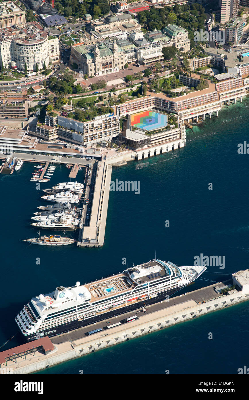 AERIAL VIEW. Cruise ship moored to a floating pontoon across from the Fairmont Hotel and the Monte-Carlo Casino. Principality of Monaco. Stock Photo