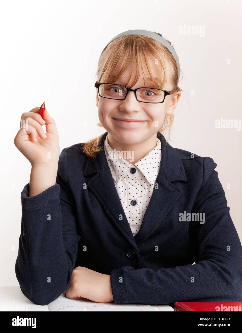 Little blond schoolgirl with glasses holds up the pen Stock Photo