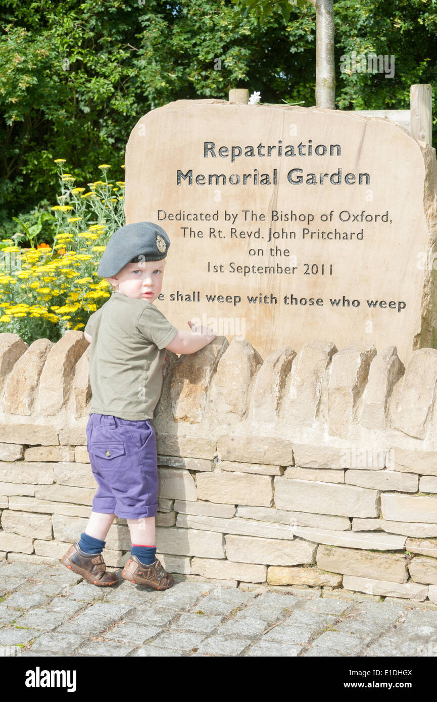 Carterton, UK. 1st June, 2014. A young child wearing his mothers RAF cap at the memorial stone in Norton Way, Carterton. Up to 10,000 motorbikes are taking part in a ride through Oxfordshire from Dry Sandford to Carterton to pay respect to the brave Service men and women killed in Service and thank the towns for their care of our heroes and their families. Credit:  Desmond Brambley/Alamy Live News Stock Photo