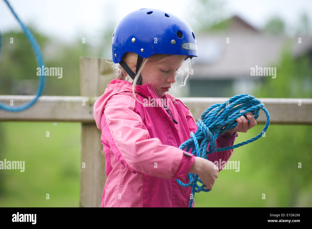 Young blonde girl child kid wearing helmet and lifejacket engaging in watersports Stock Photo