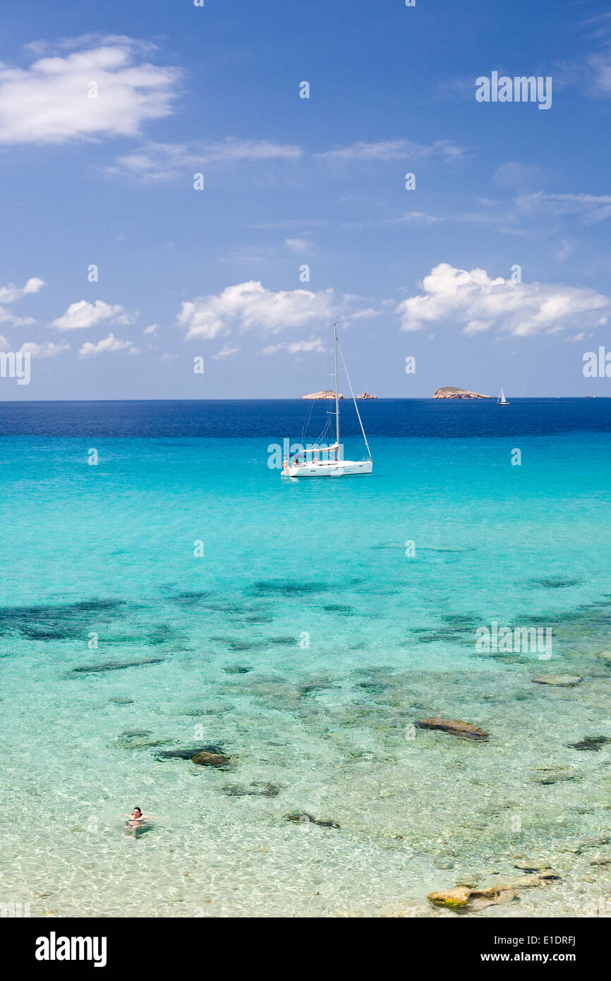 crystal clear turquoise blue Mediterranean sea in Ibiza with yacht and islands in the background Stock Photo