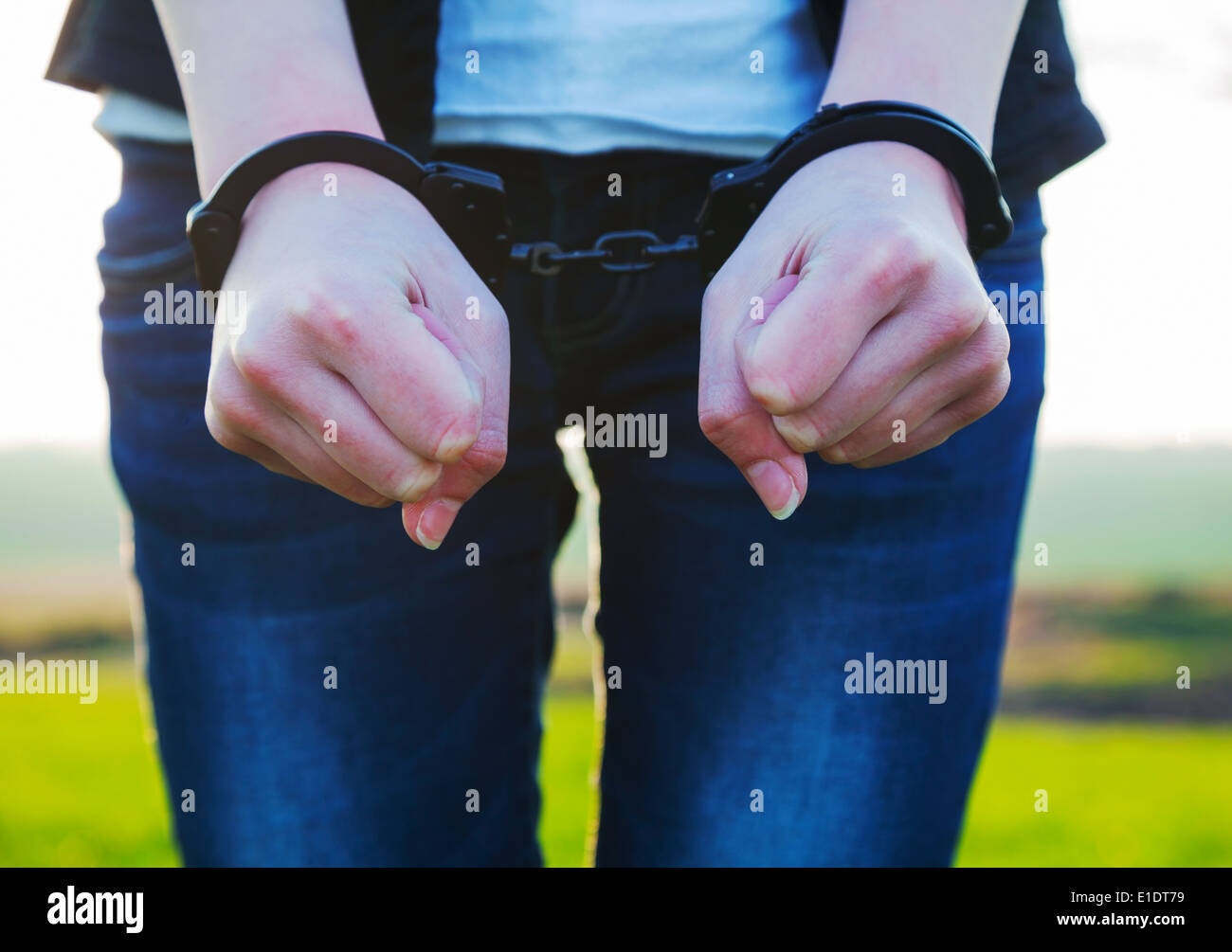 Woman with handcuffed hands outdoors Stock Photo