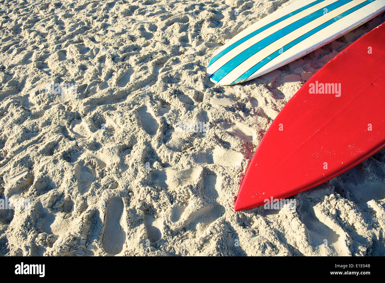 Surfboard and stand up paddle long board in bright red and blue stripes on Copacabana Beach Rio de Janeiro Stock Photo