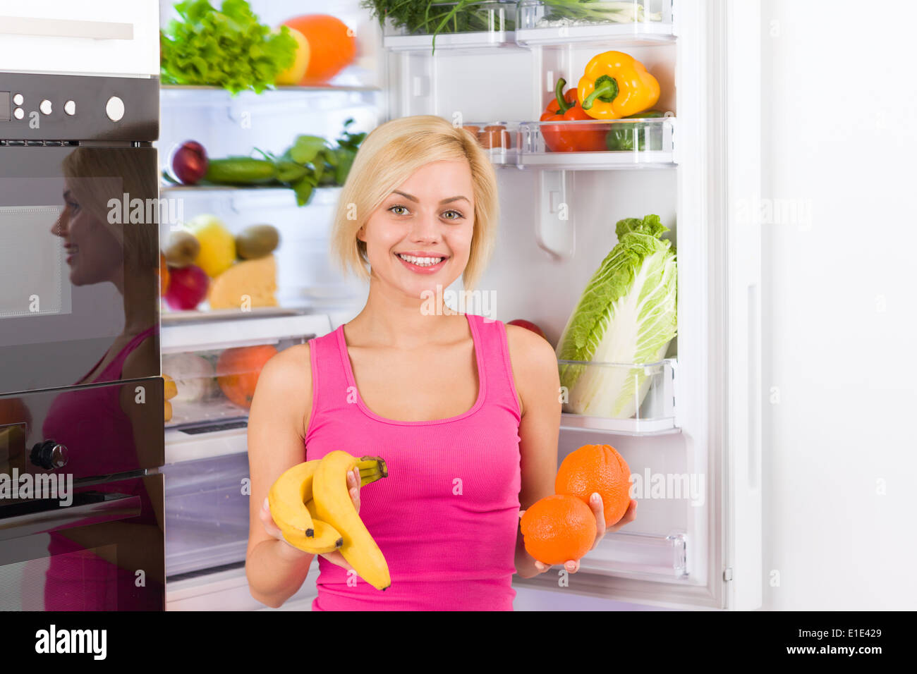 woman banana orange refrigerator Stock Photo