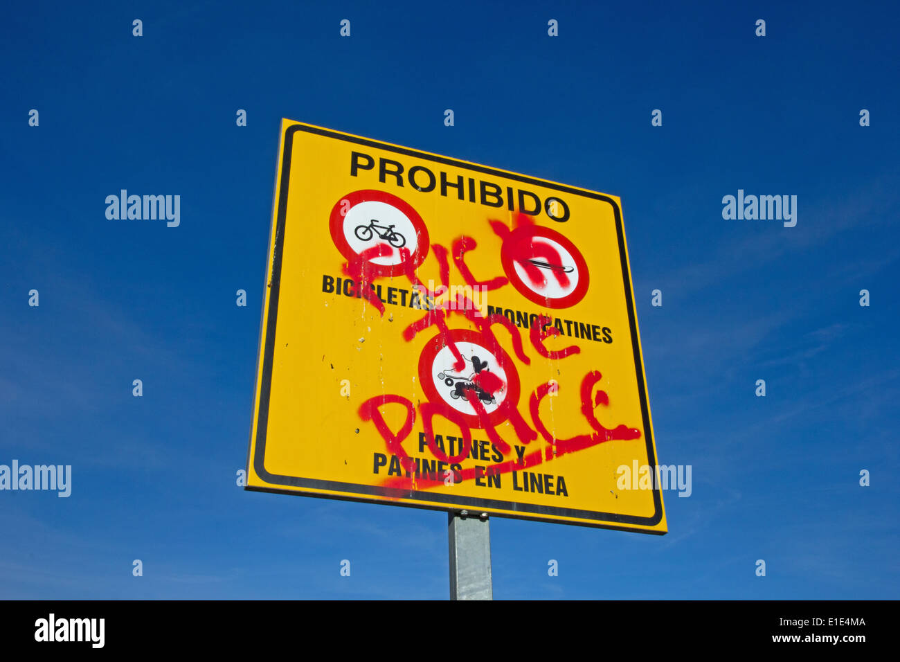 Sign prohibiting cycling, skateboarding and in-line skating, defaced with anti police graffiti, Spain Stock Photo