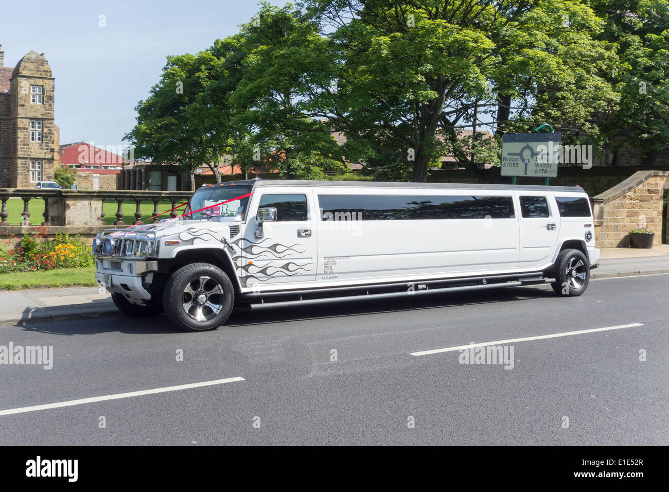 A white Hummer stretched limousine with red ribbons wedding decoration Stock Photo