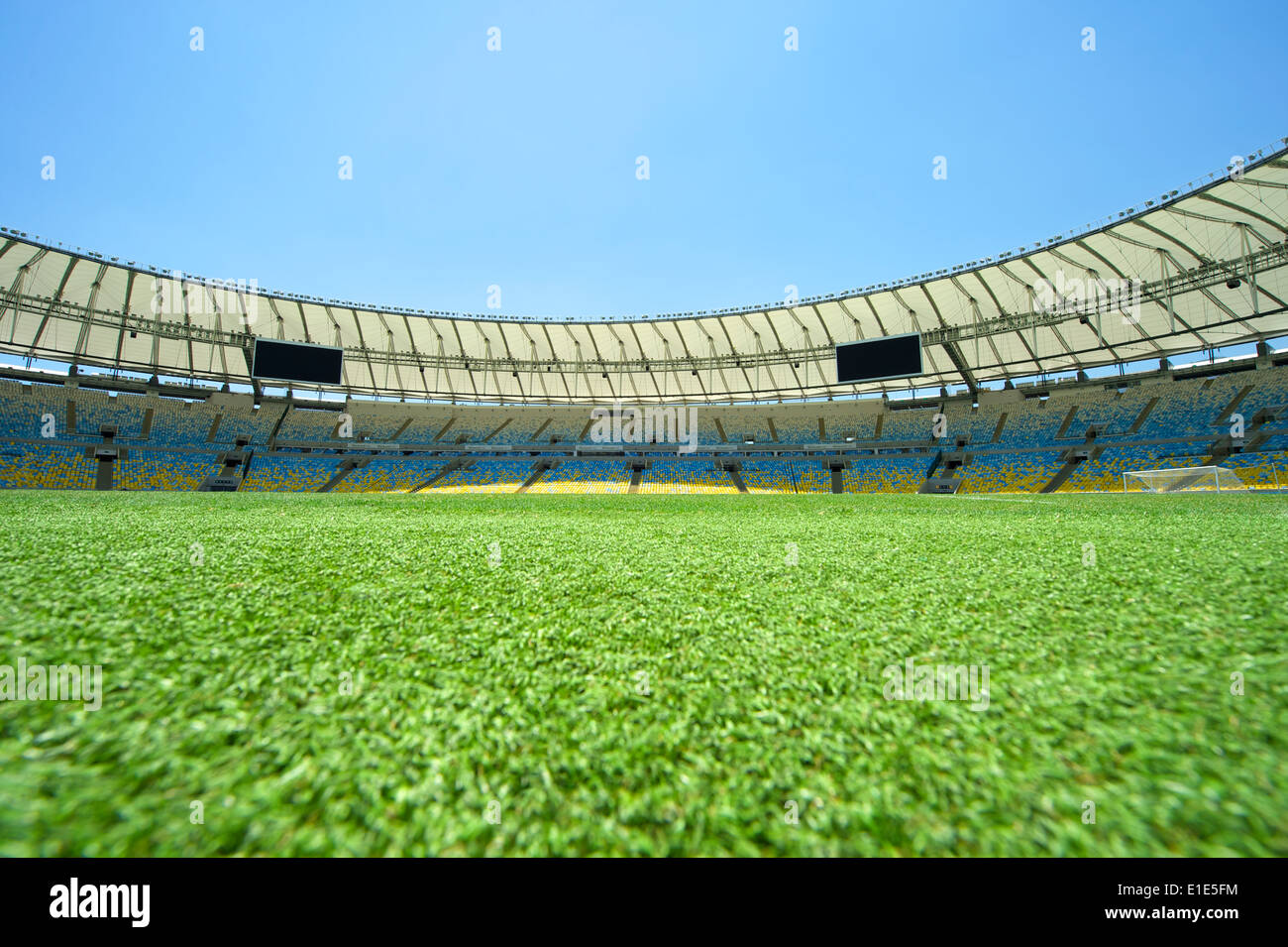 Pitch-level view of Maracana football soccer stadium under bright blue sky Stock Photo