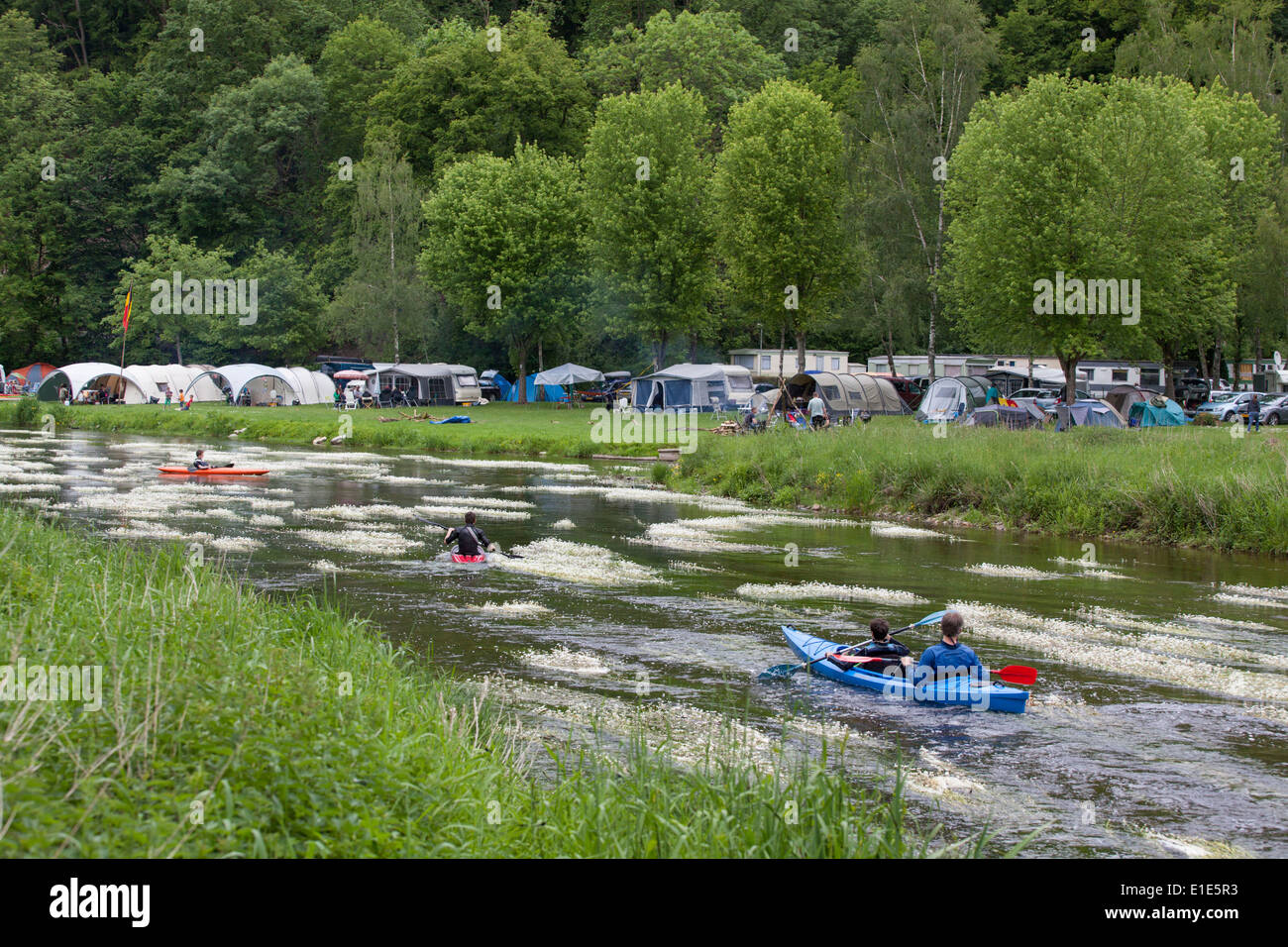 Tourists in canoes passing a camping along the Semois river in the Ardennes, neighborhood of Mortehan Stock Photo