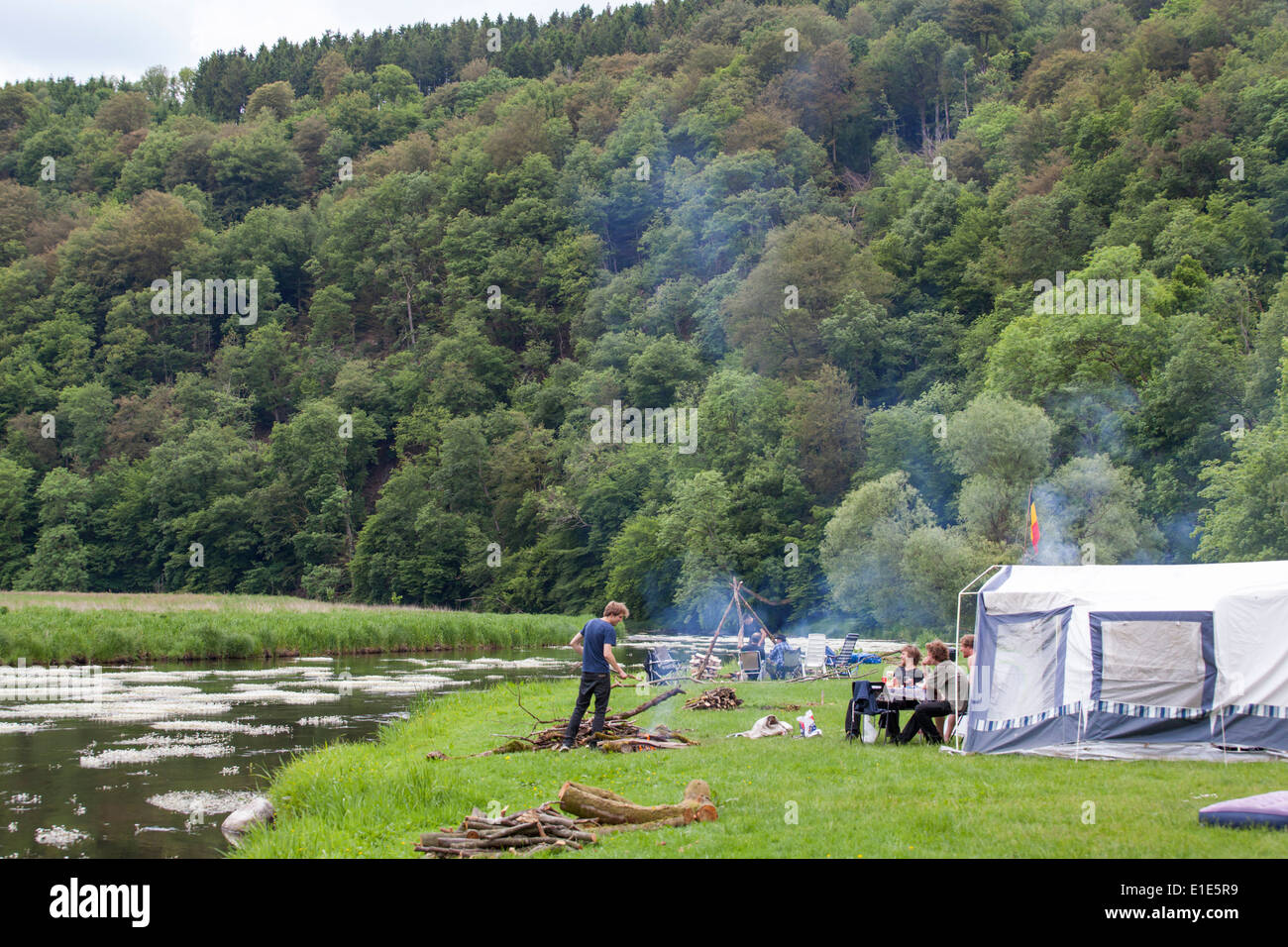 Tourists making a campfire at a camping along the Semois river in the neighborhood of Mortehan in Belgium Stock Photo