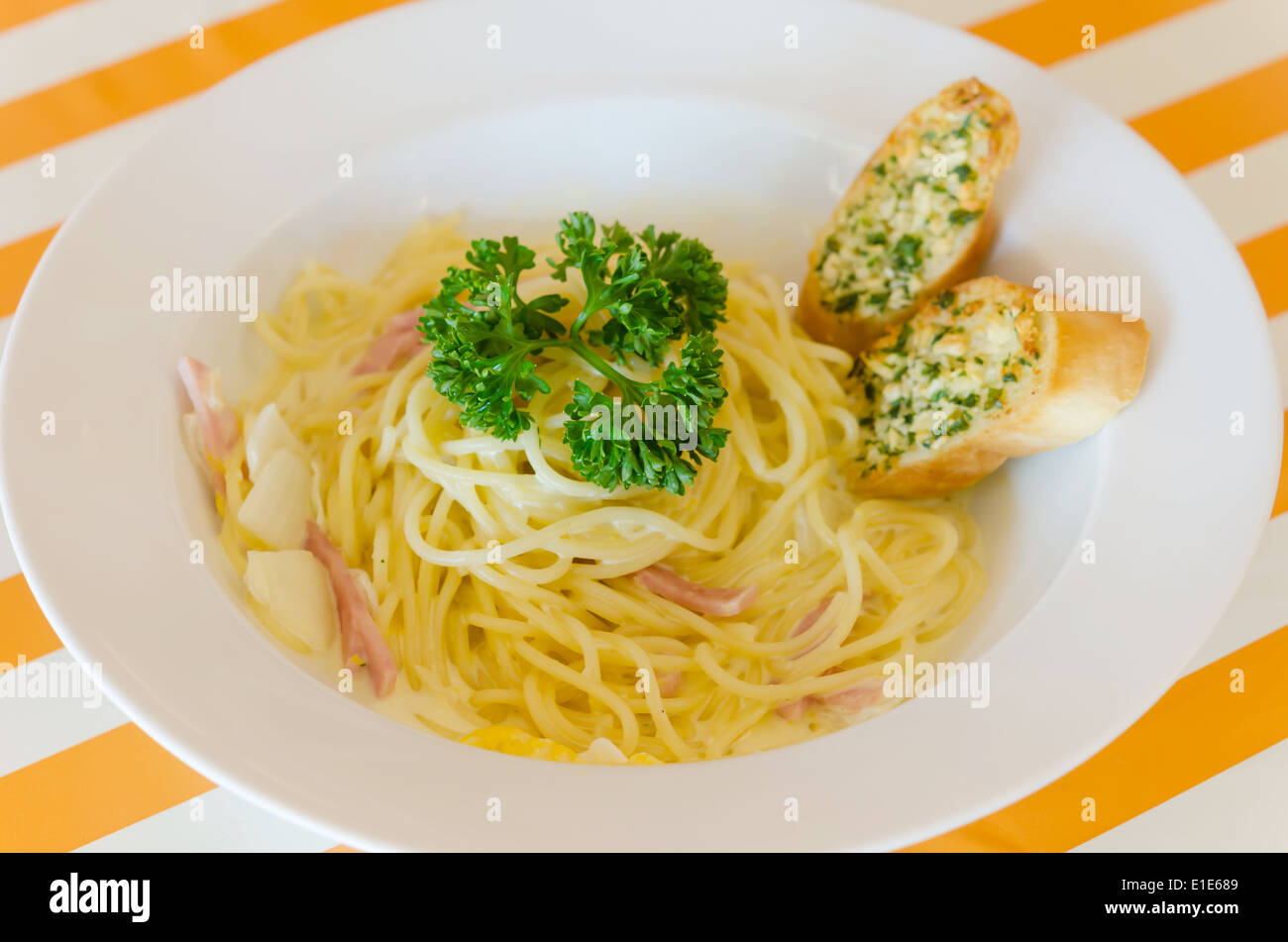 Spaghetti Carbonara with bacon and garlic bread on dish Stock Photo