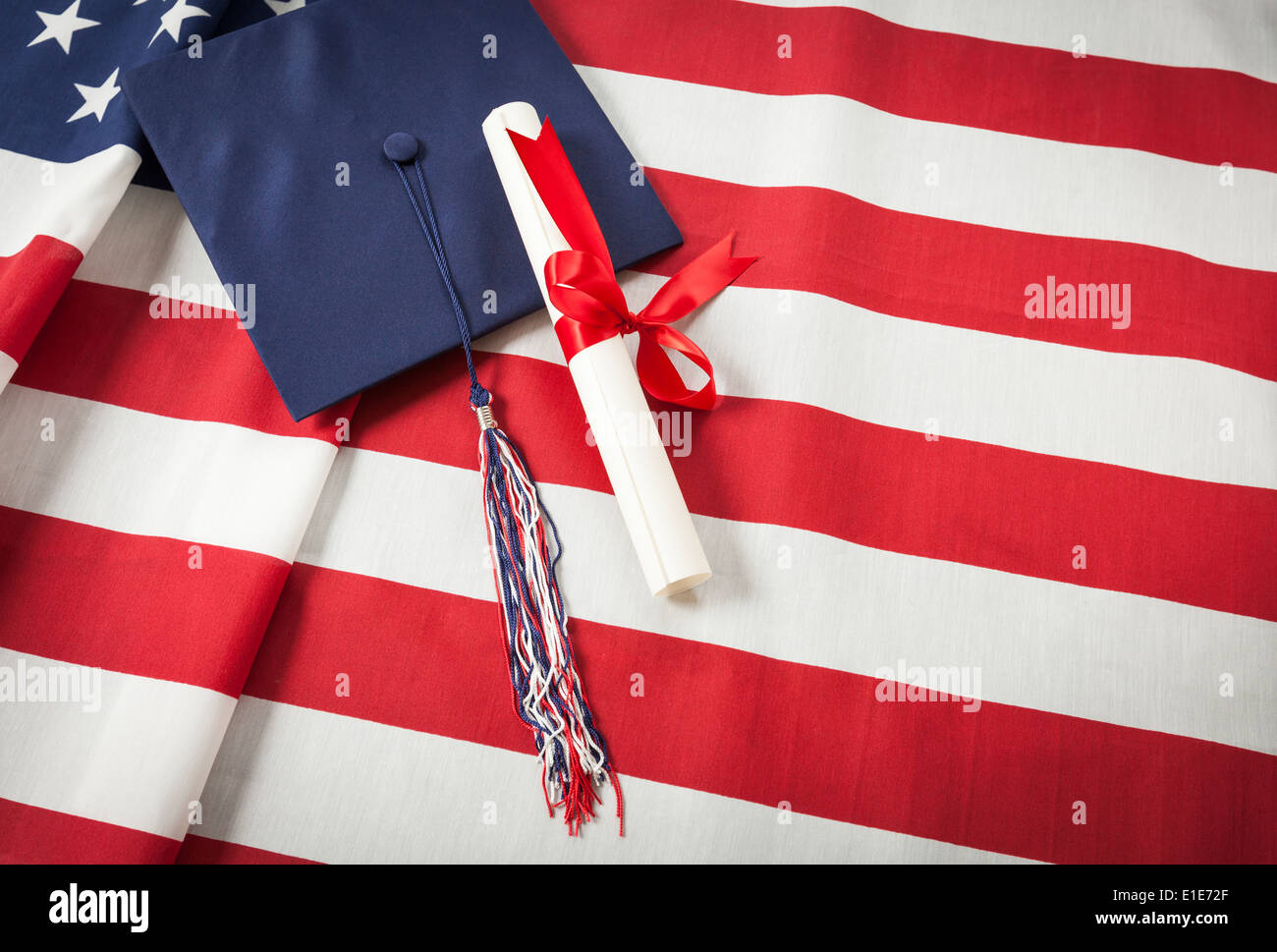 Graduation Cap with Tassel and Red Ribbon Wrapped Diploma Resting on