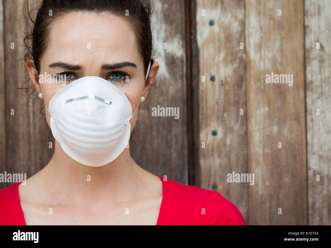 An unhappy woman wearing a face mask to deal with virus or pollution. Stock Photo