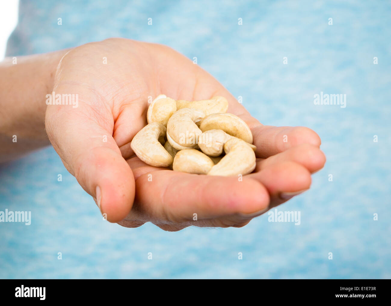 Hand holding a heap of organic cashew nuts Stock Photo