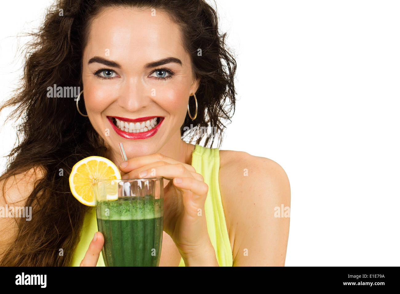 Beautiful healthy smiling woman holding and about to drink an organic green smoothie. Isolated on white. Stock Photo