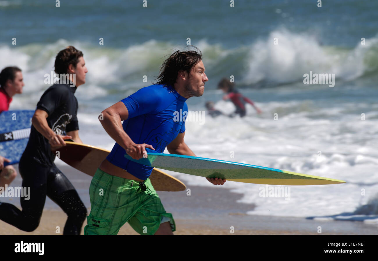 Group of Skimboard Competitors Run to the Waves Stock Photo