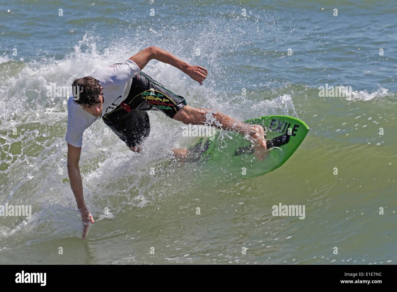 Skimboard Competitor in Rides a Wave Stock Photo