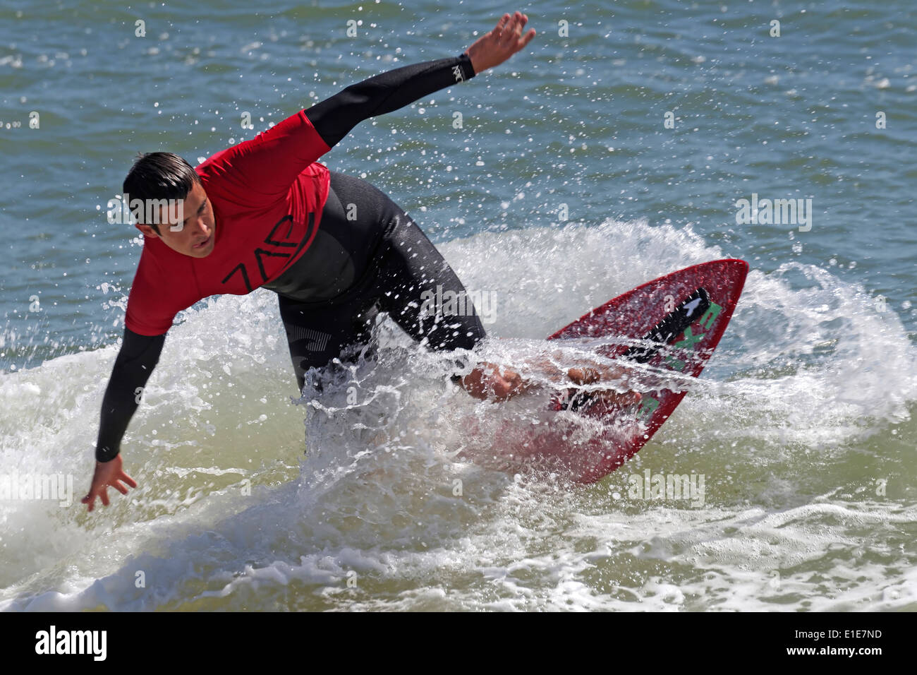 Skimboard Competitor Wearing Wetsuit Rides a Wave Stock Photo
