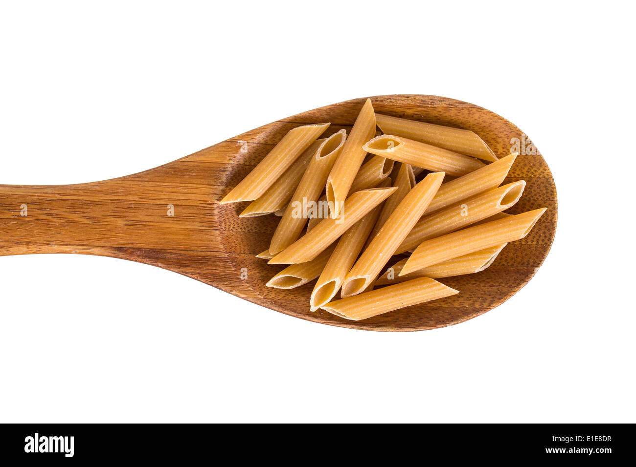 A wooden spoon with wholemeal penne pasta. Isolated on white. Stock Photo