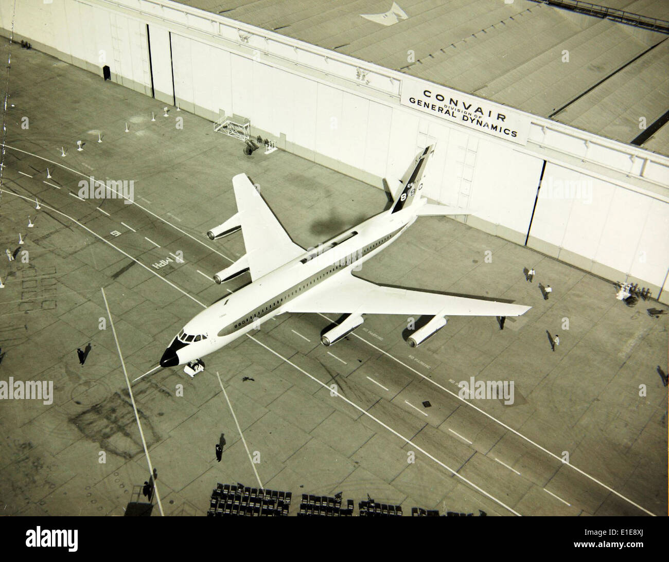 This image shows the rollout ceremony of the Convair 880 (N801TW), a commercial airliner prototype, at the Convair factory during the 1950s. The 880 was known for its speed and innovative design. Stock Photo