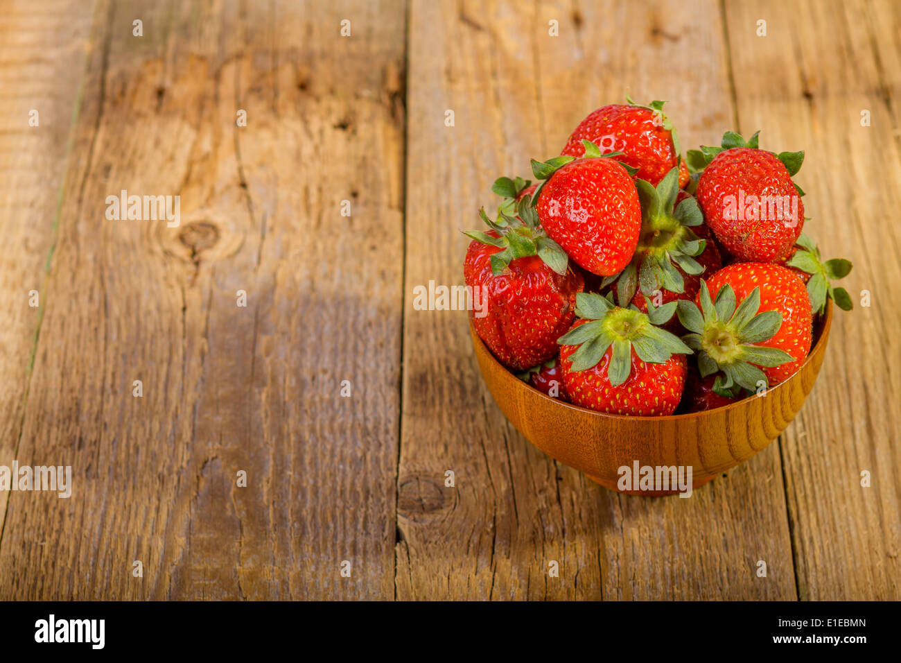 fresh strawberries in wood bowl on old wooden background Stock Photo