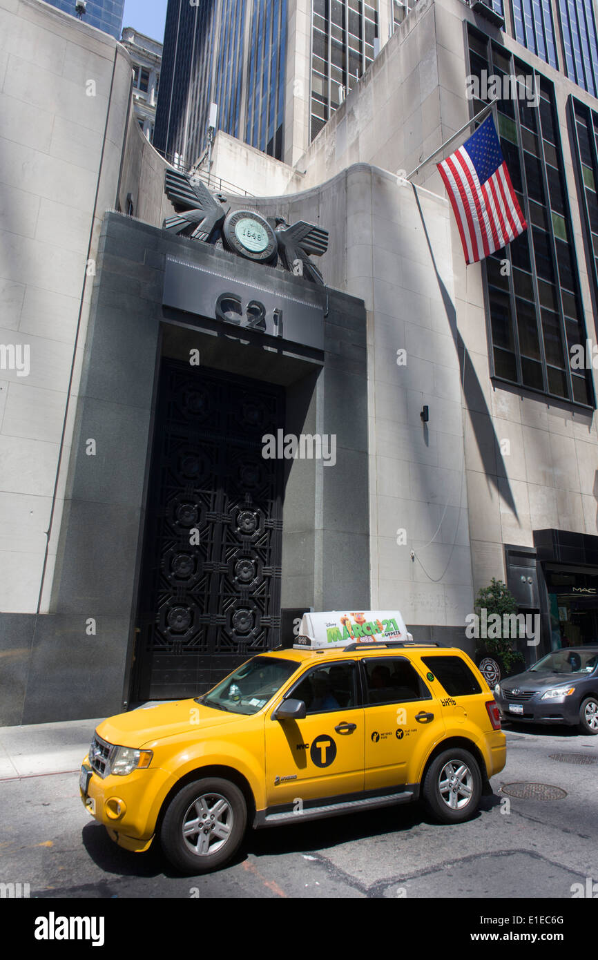 A hybrid taxi cab passes the tall doorway of the East River Savings Bank in Lower Manhattan, New York City. Stock Photo