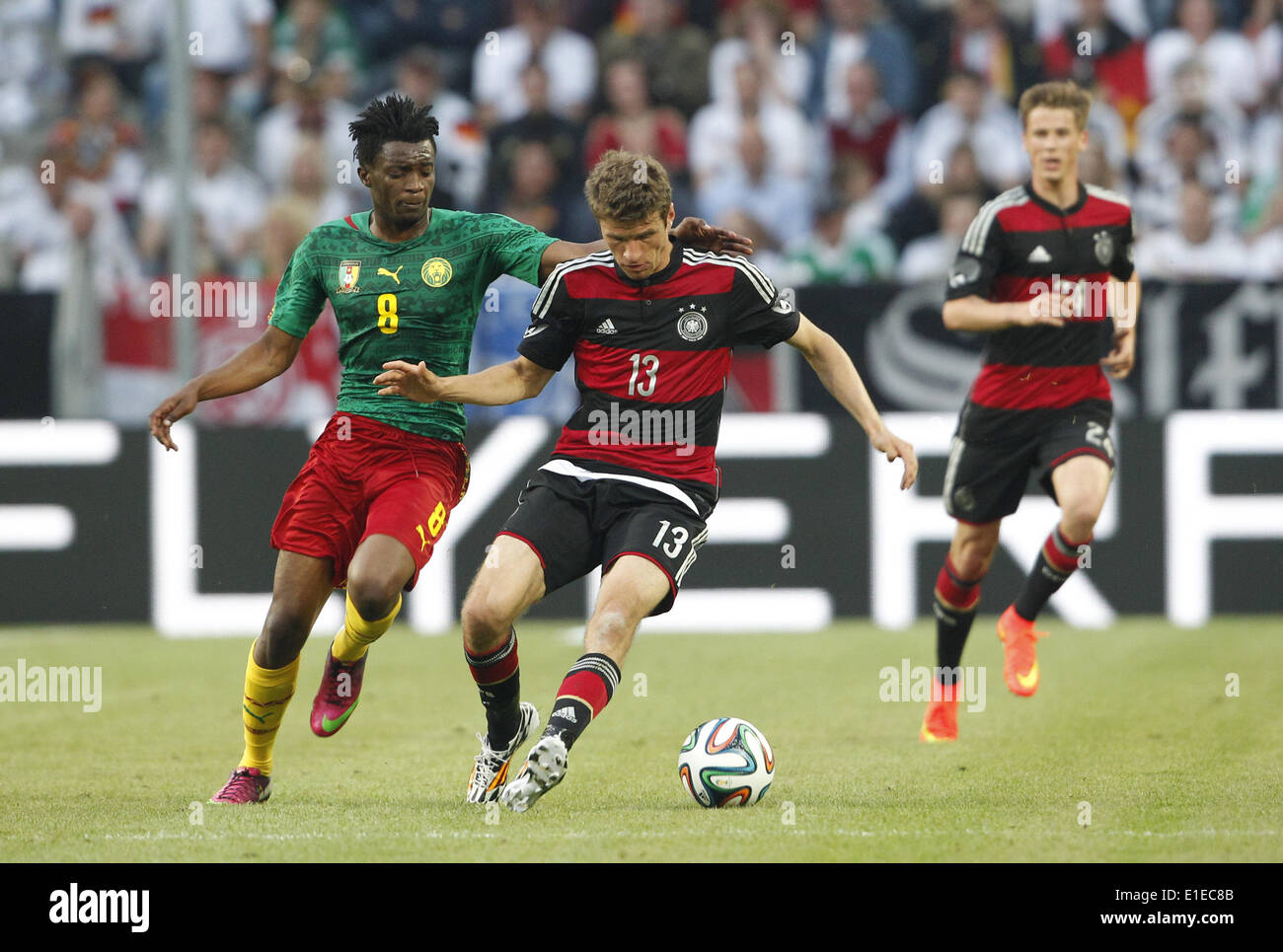 Moenchengladbach, Germany. 01st June, 2014. Germany's Thomas Mueller (C) in action against Cameroon's Benjamin Moukandjo during the friendly soccer match between Germany and Cameroon at the Borussia Park stadium in Moenchengladbach, Germany, 01 June 2014. Photo: Roland Weihrauch/dpa/Alamy Live News Stock Photo