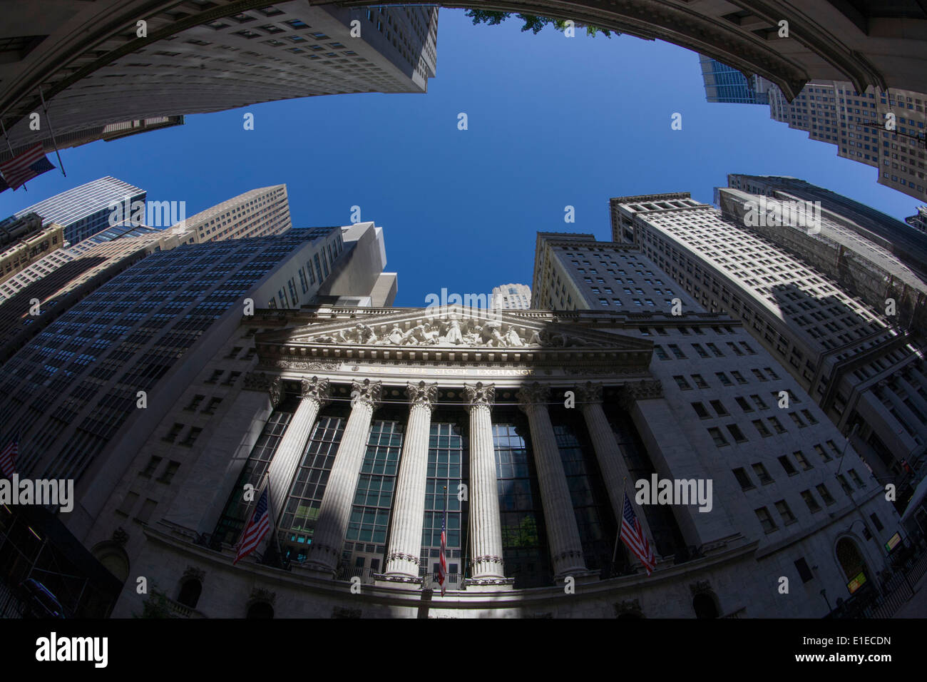 Distorted fish-eye lens view of classical pillars and American flag hanging in front of the New York Stock Exchange (NYSE) on Wall Street, Lower Manhattan. Stock Photo
