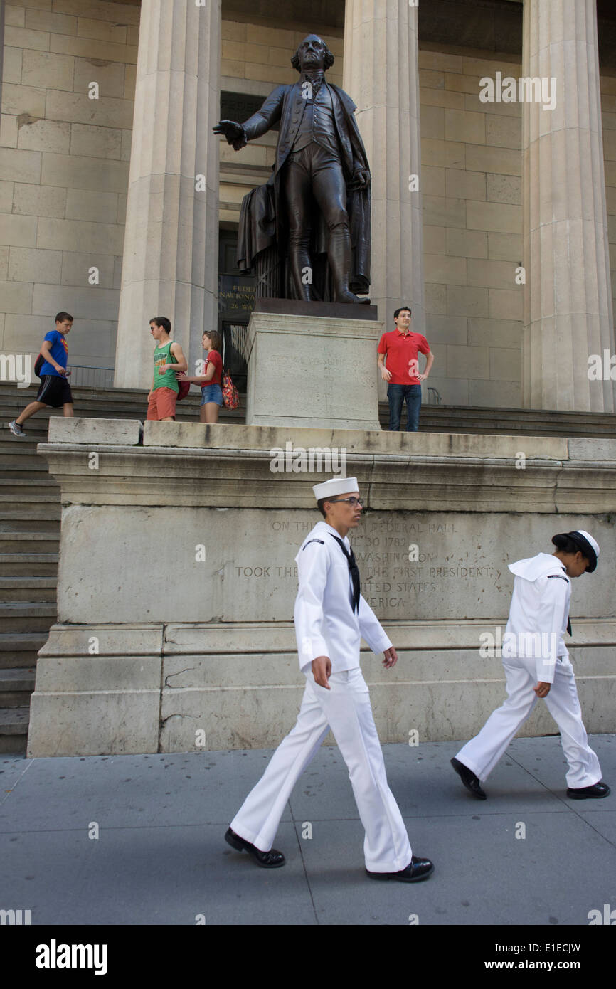 Two US Navy sailors walk past the statue of first President