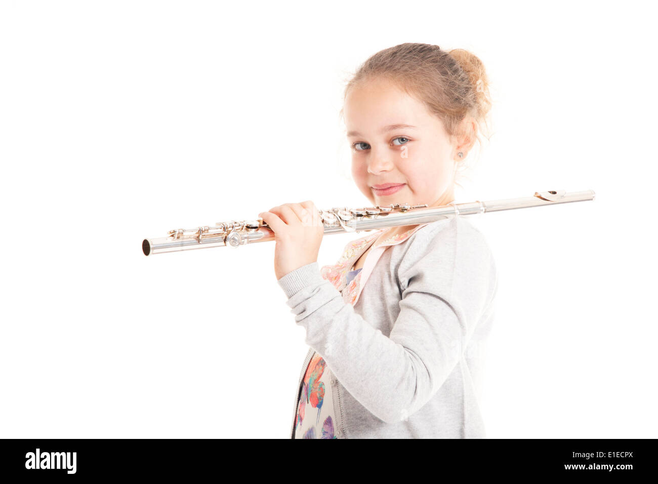 young girl holding flute against white background in studio Stock Photo