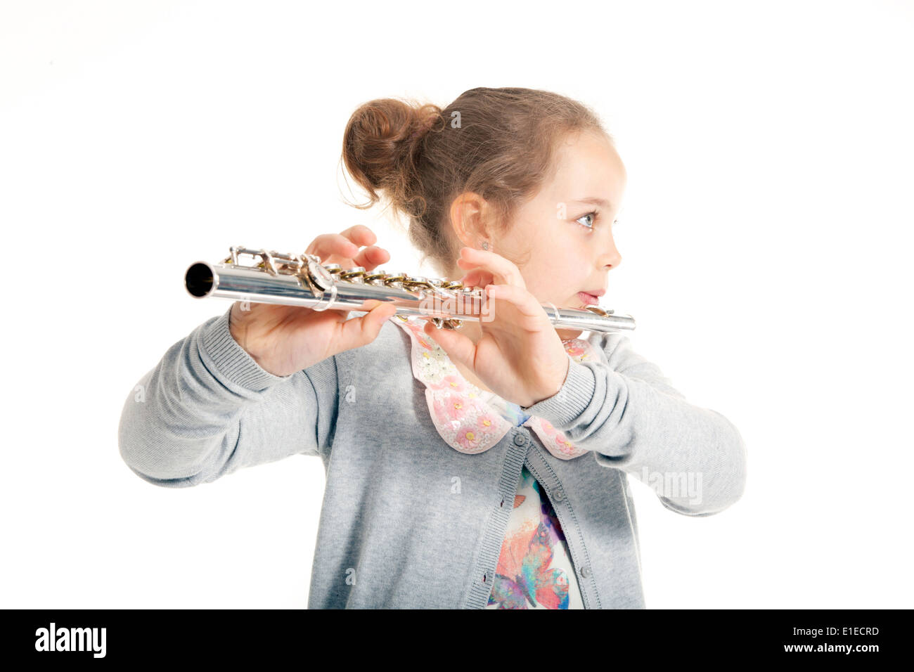young girl playing flute against white background in studio Stock Photo
