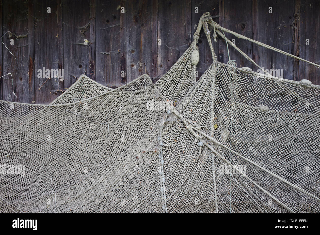 Old fishing nets hanging at wooden barn wall in Dießen, Ammersee Stock Photo