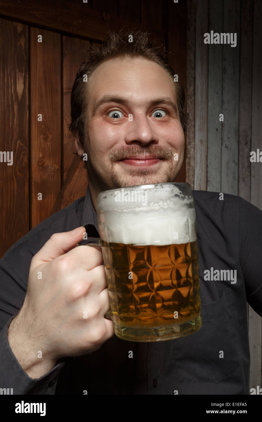 Happy man drinking beer from the mug. Stock Photo