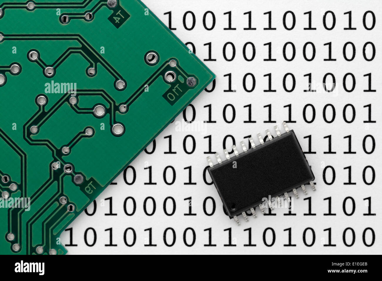 An electronic circuit board and integrated circuit chip with printed digital data binary ones and zeros in background. Stock Photo
