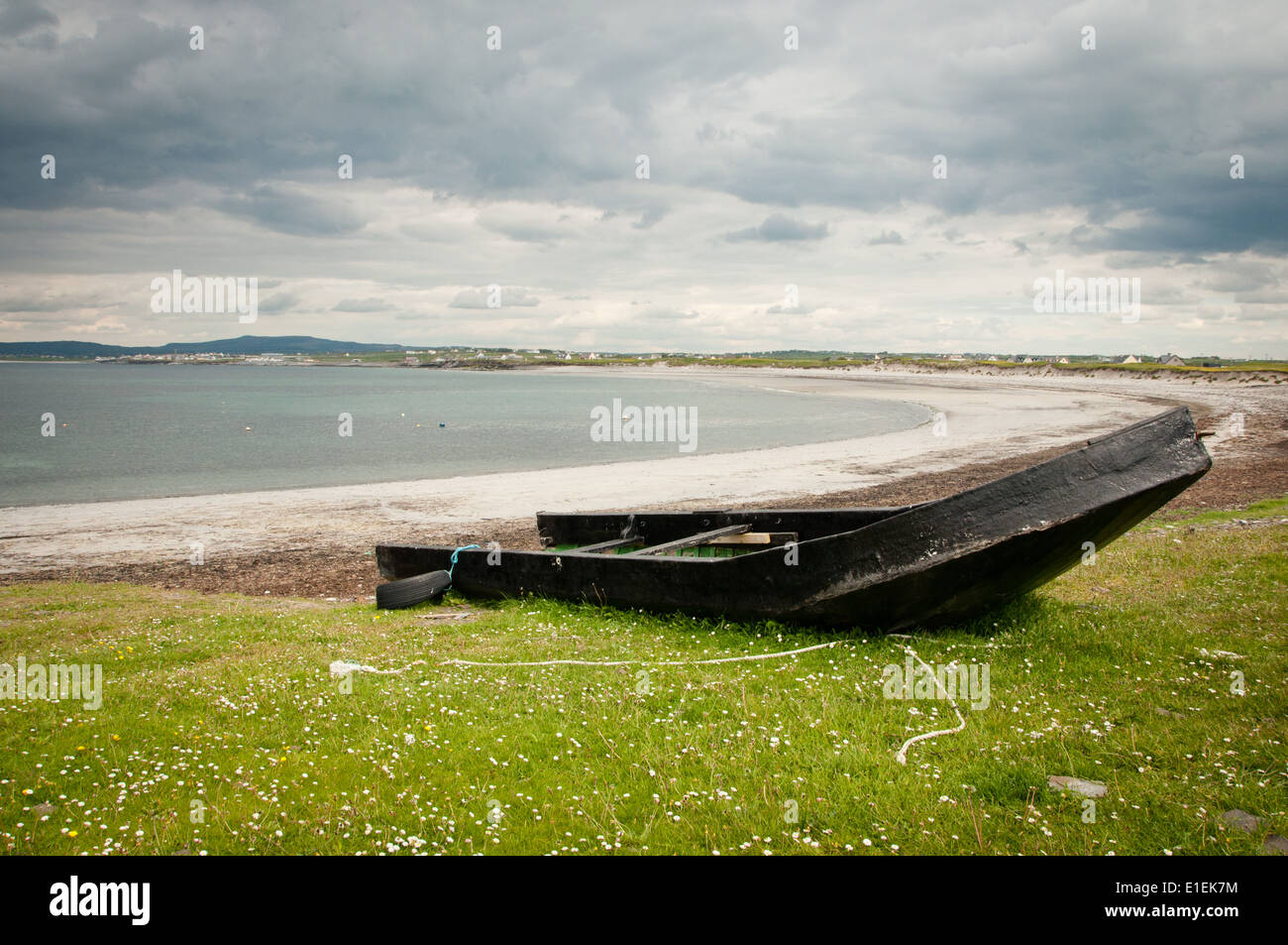 Old and Battered Currach Traditional Boat drawn up on Beach on West Coast of Ireland Stock Photo
