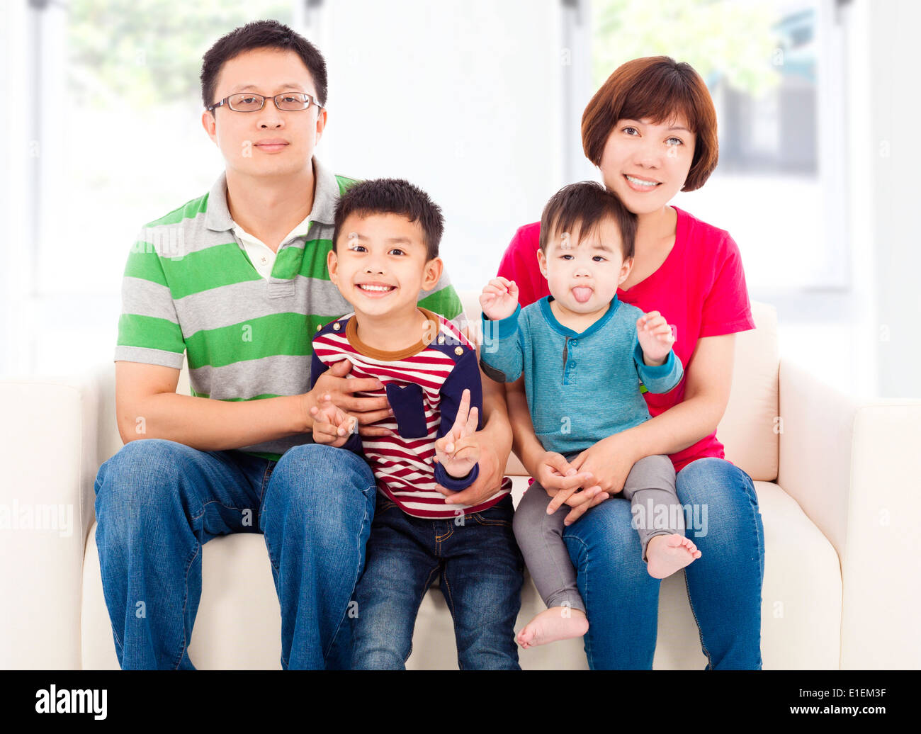 happy asian family sitting on a white leather sofa Stock Photo