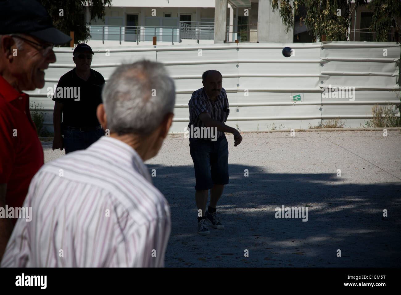 A competitor throws a steel ball during a game of boules in the town of