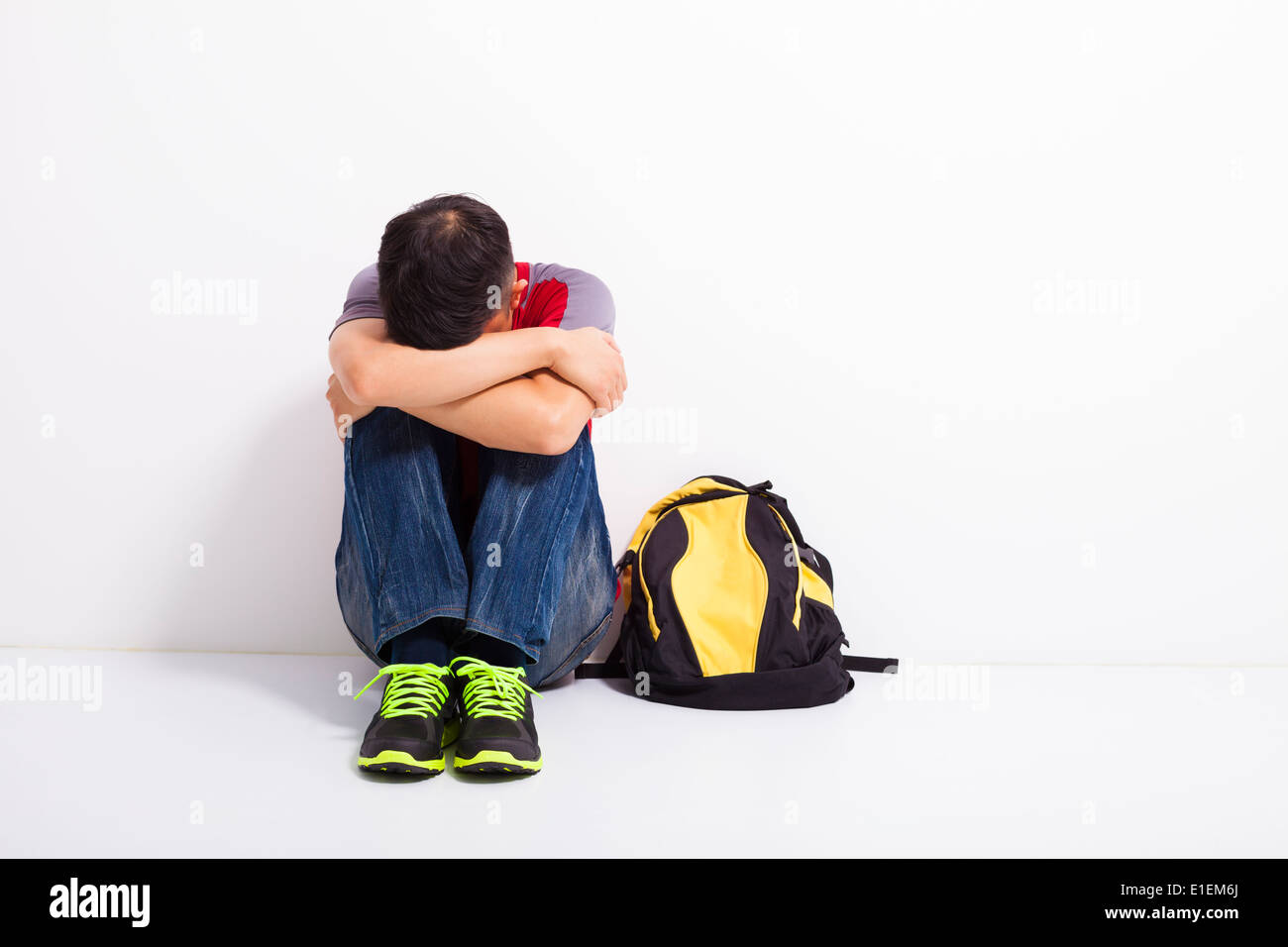 terrified student sitting on the floor Stock Photo