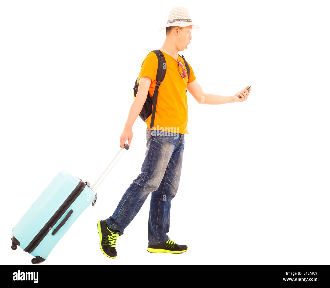 young backpacker carrying a baggage and holding a smartphone Stock Photo