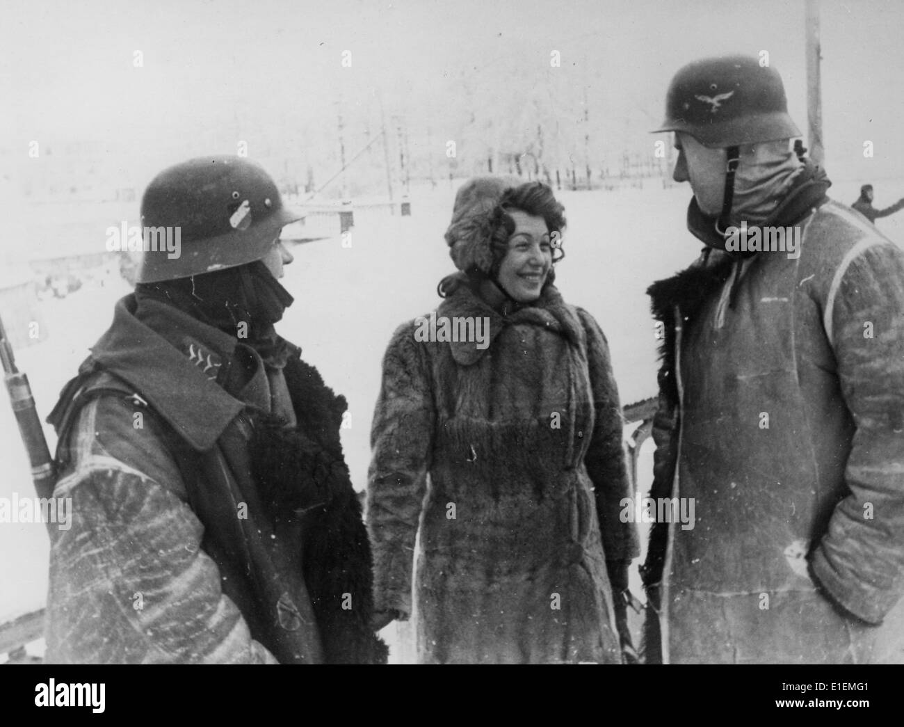 Soldiers of the German Wehrmacht stand next to an actress of a theatre group at the Eastern Front, published 06 February 1942. Propaganda text! from Nazi news reporting on the back of the picture: 'Winter deployment of a front stage. A female artist in conversation with two soldiers. Furs protect against the great cold of the Russian winter.' (Defects in the quality due to the historic picture copy) Fotoarchiv für Zeitgeschichtee - NO WIRE SERVICE - Stock Photo