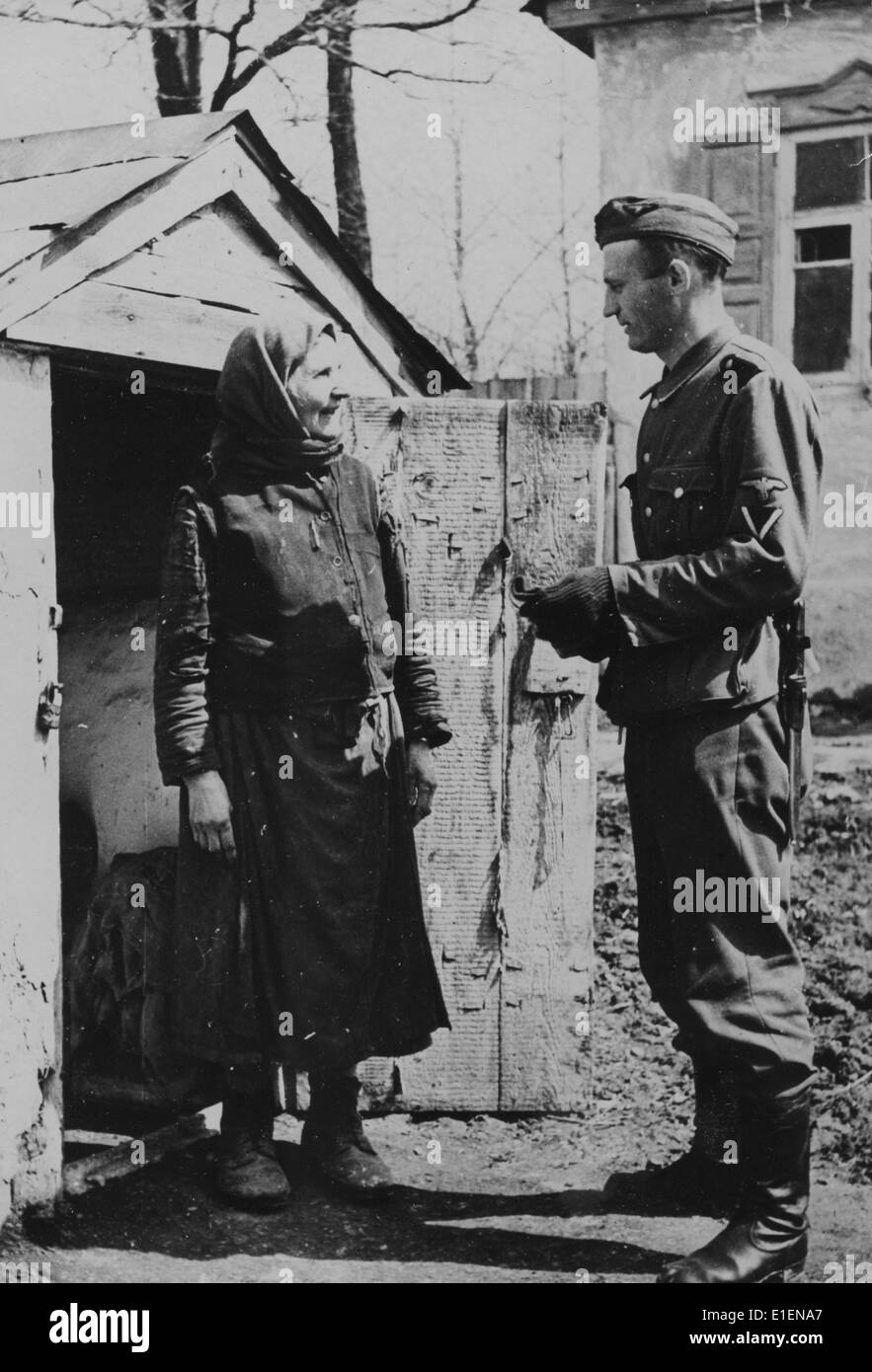 The picture from a Nazi news report shows a German soldier talking with a native resident at the Eastern Front in May 1942. The original propaganda text on the back of the picture reads: 'Out soldiers are able to find their bearings in all countries and languages. Here, a German soldier negotiates with a Ukrainian farmer.' Fotoarchiv für Zeitgeschichtee - NO WIRE SERVICE Stock Photo