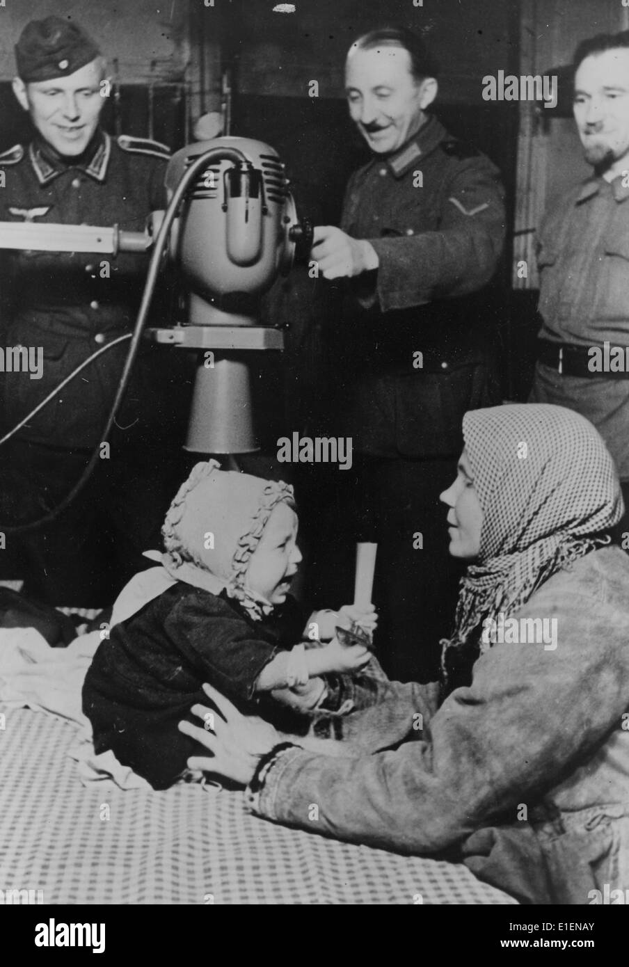 The picture from a Nazi news report shows an injured local child being X-rayed by German paramedics at the Eastern Front in June 1943. The original Nazi propaganda text on the back side of the picture reads: 'Exemplary field hospital stations for country-specific association and those willing to help. German army doctors have set up Russian field hospital over time with their paramedic personnel. More and more, they are being expanded into self-sufficient field hospitals. In the x-ray station, which is partially manned by German personnel, even civilians are admitted under certain circumstance Stock Photo