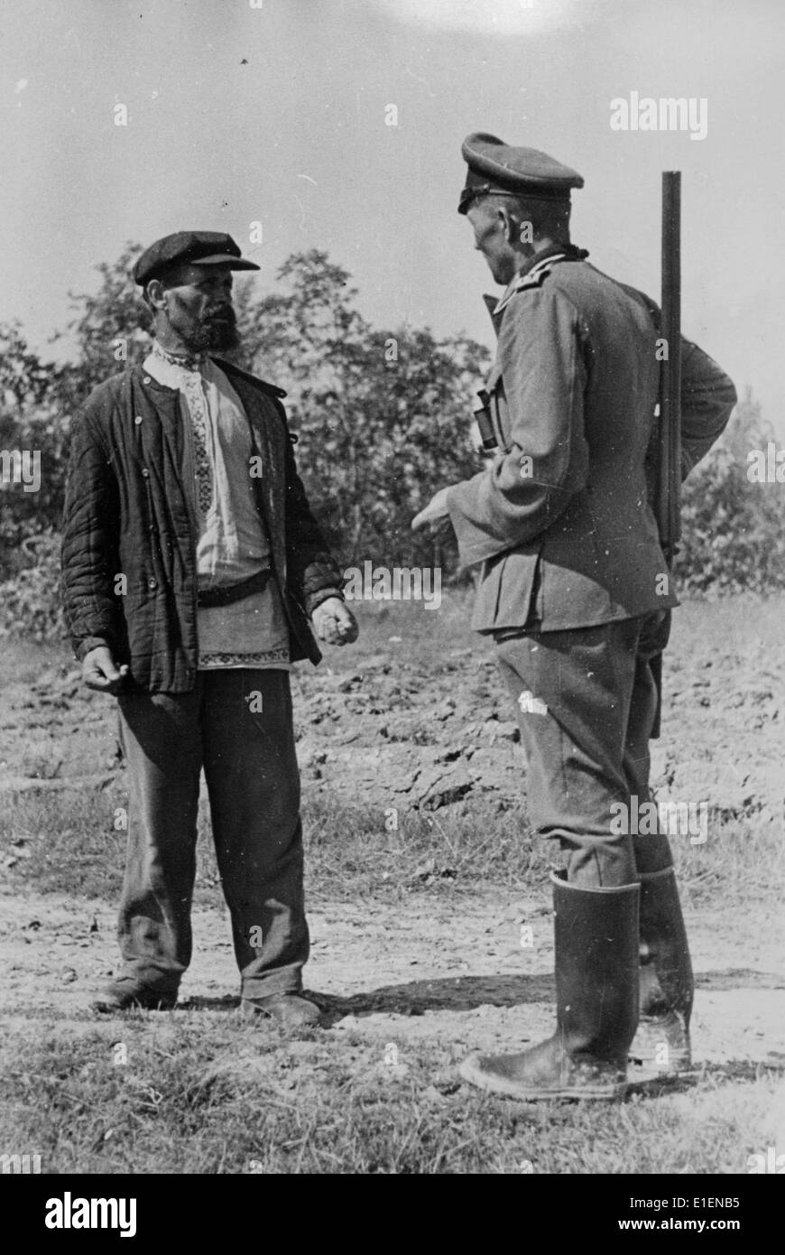 The picture from a Nazi news report shows a German soldier talking with a native resident at the Eastern Front in May 1942. The original propaganda text on the back of the picture reads: 'During a break Starosch, the mayor (Starosta = Eldest), tells German soldiers about the horrible time before the German troops arrived and with them order and honest work.' Fotoarchiv für Zeitgeschichtee - NO WIRE SERVICE Stock Photo