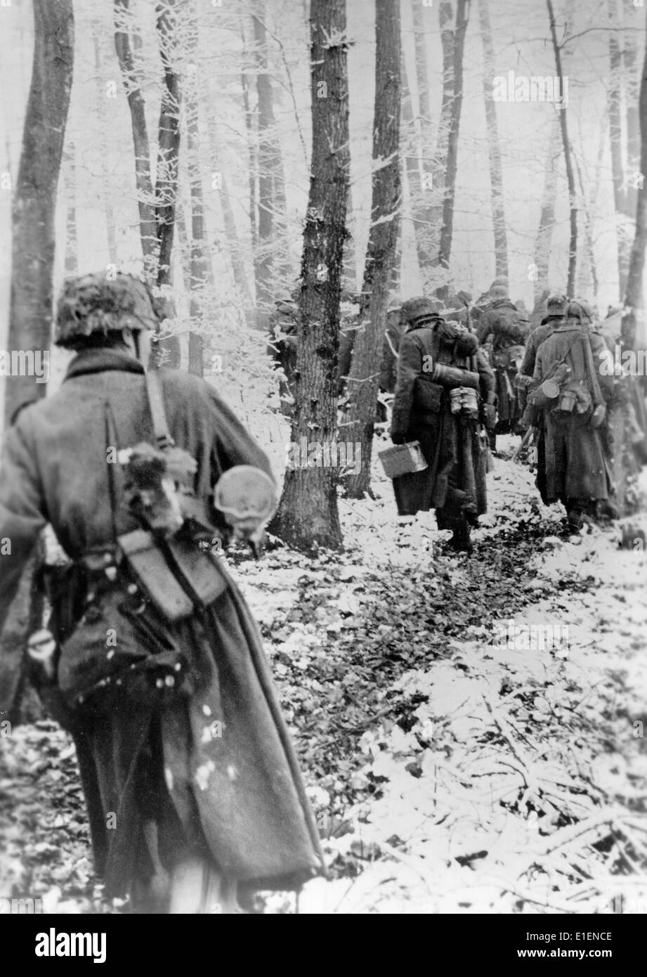 German army fights the American troops along the Western Front in December 1944. The Nazi propaganda text dated 30 December 1944 reads: 'The winter battle in the West. Despite bitter resistance by the opponents, our troops continue to advance in the West. Our picture shows: German infantry marching through a snow-covered beech forest.' Fotoarchiv für Zeitgeschichtee - NO WIRE SERVICE Stock Photo