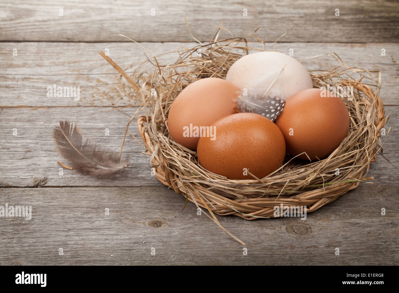 Eggs nest over wooden table background Stock Photo - Alamy