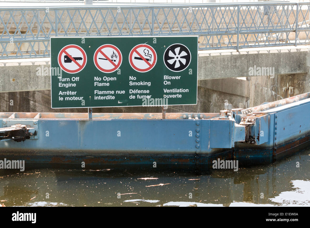 Bilingual sign on top of canal lock doors instructing boaters Stock Photo