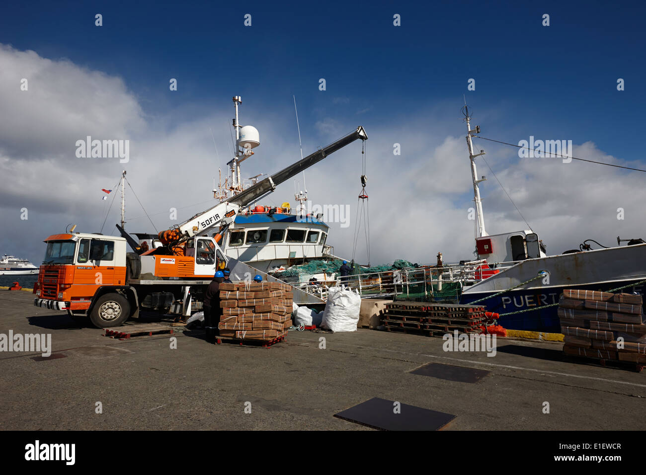 unloading patagonian toothfish from puerto ballena fishing boat at quay in Punta Arenas port Chile Stock Photo