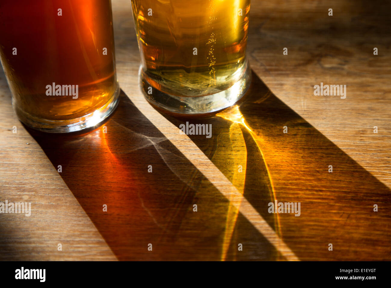 A couple of pints of beer in the sunlight on a pub table Stock Photo
