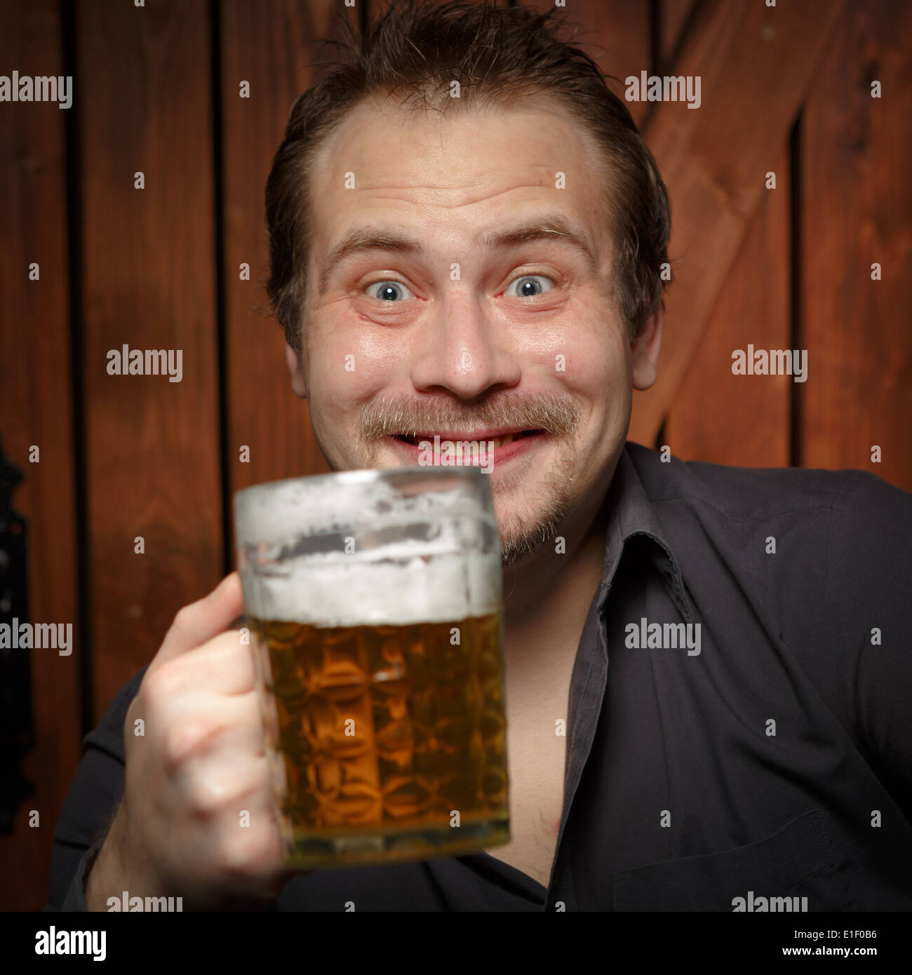 Happy man drinking beer from the mug. Stock Photo