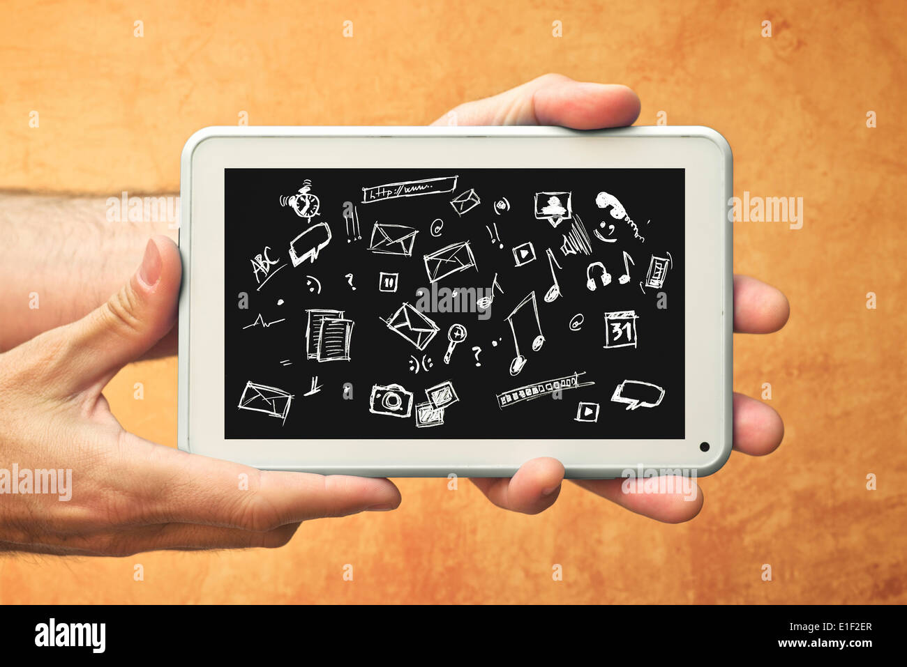 Male Hands with tablet computer and various doodle icons. Using modern technology gadgets. Stock Photo